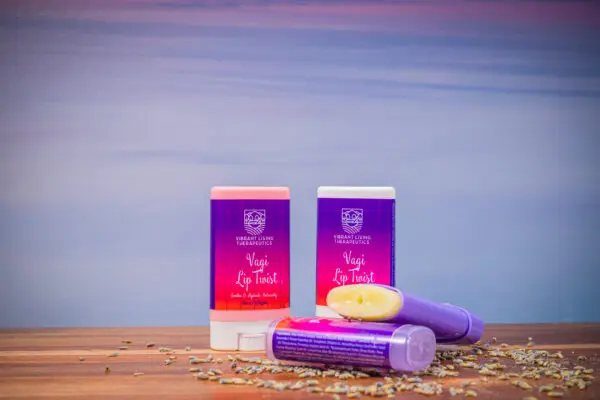 Two purple and red lip balms sitting on a table.