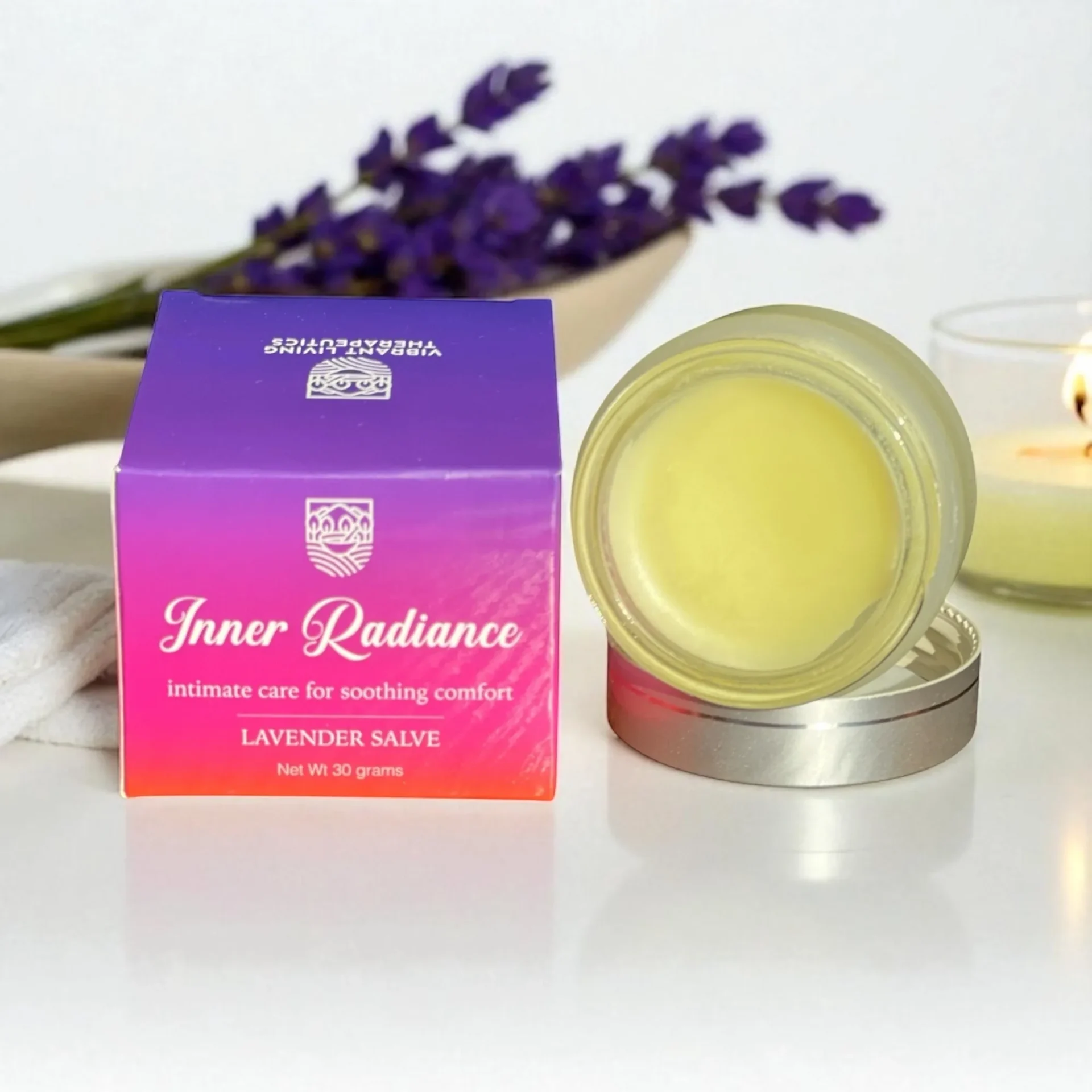 Lavender salve with purple box, candle, flowers.